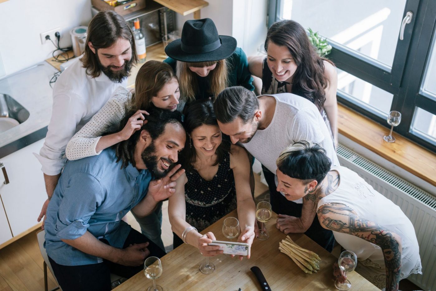 Depicts group of people actively engaged in content on someone's phone