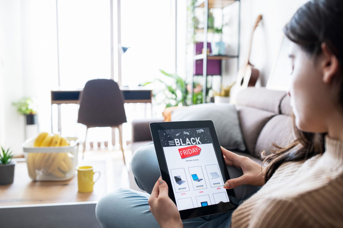 Woman browsing black Friday deals on her iPad at home