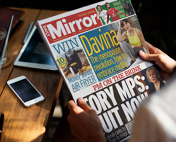 Person holding Daily Mirror Newspaper