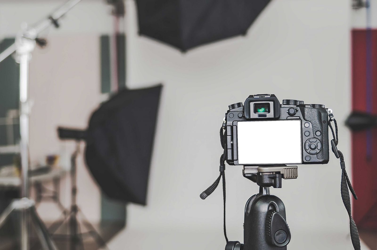 Image shows a camera on a tripod pointing towards film making equipment in a studio.