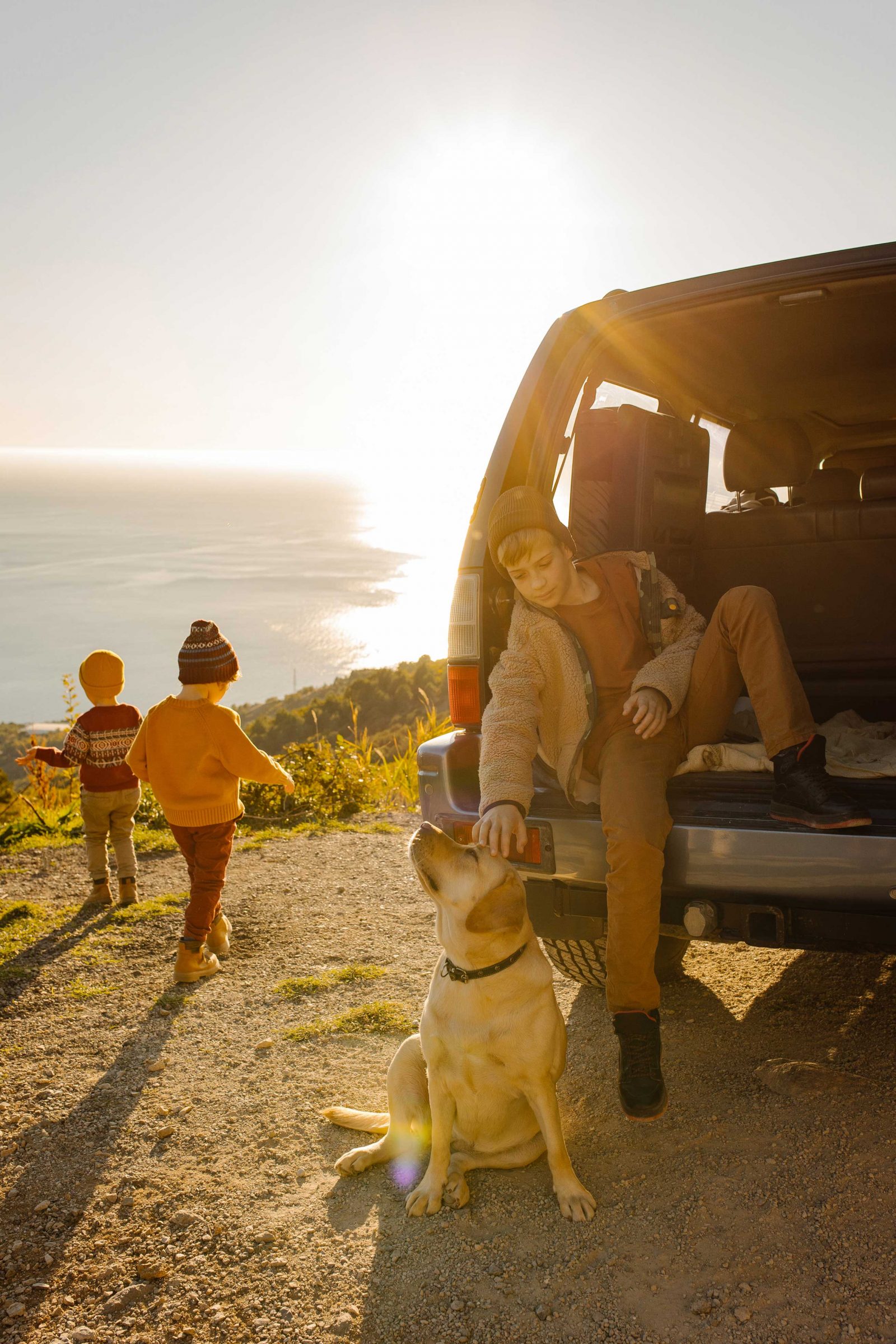 Group of children, handsome father and beautiful mother and their dog golden retriever enjoying and fun outdoor lifestyle road trip on autumn holiday vacation. Concept family travel with children and animals, local travel.